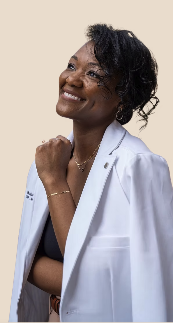 Dr. Whit smiling in a white coat, representing holistic and functional medicine care for women in San Antonio.