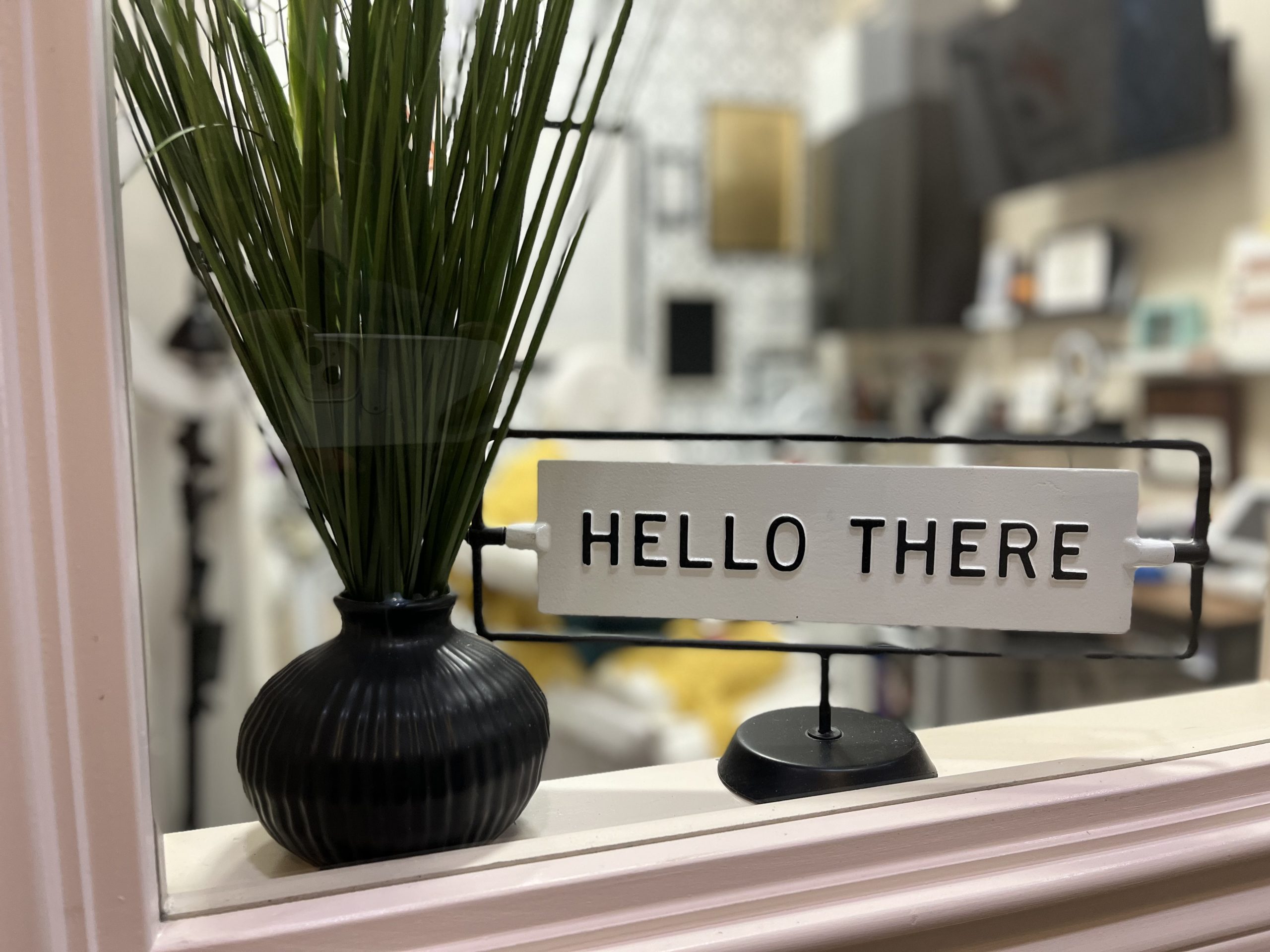 Welcome to Balance Skin & Wellness – You Belong Here Hello There welcome sign next to a plant at the entrance of Balance Skin & Wellness, setting a friendly tone for new clients.