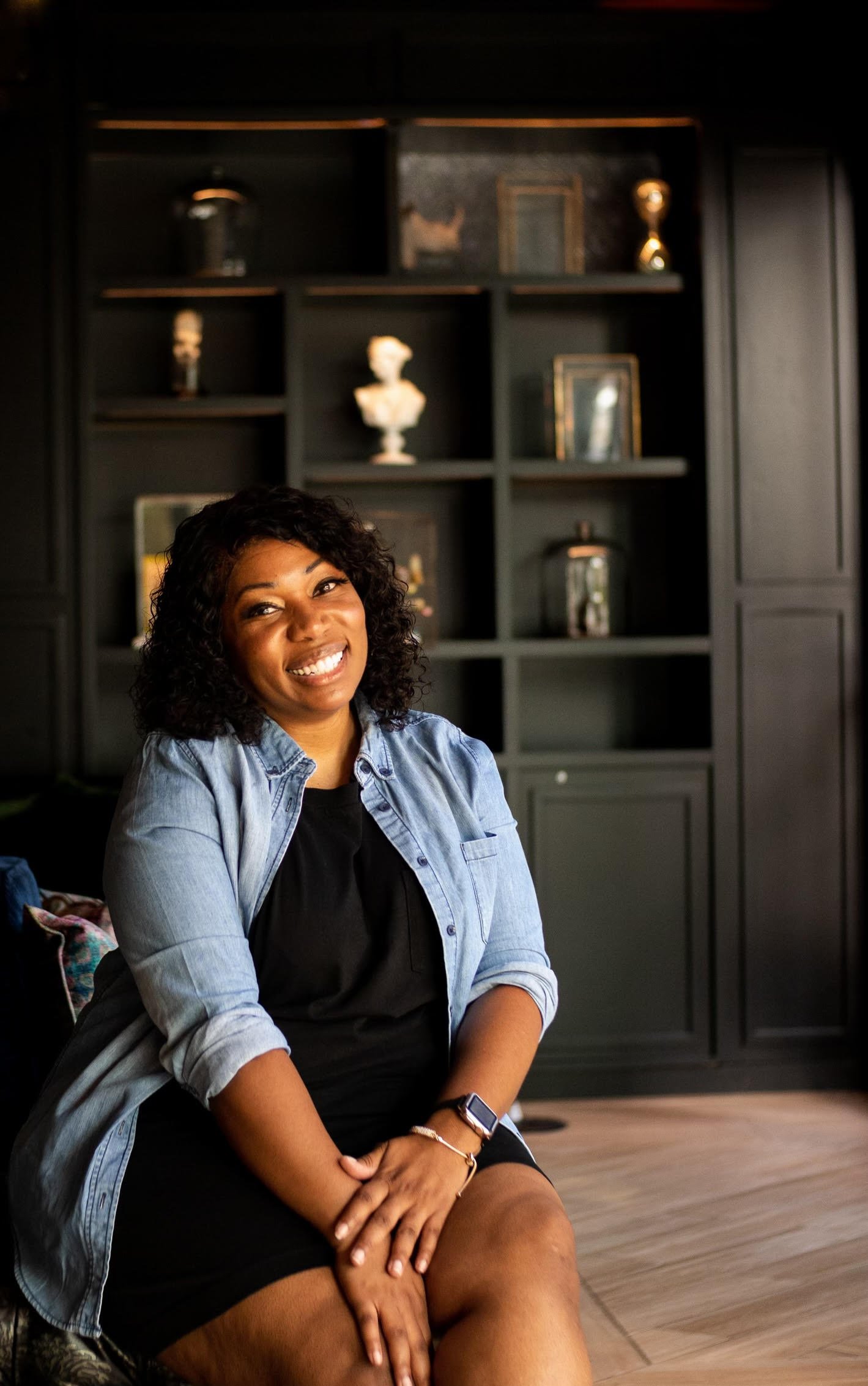 Smiling Black woman seated with confidence, representing inclusive skincare and wellness expertise at Balance Skin & Wellness.