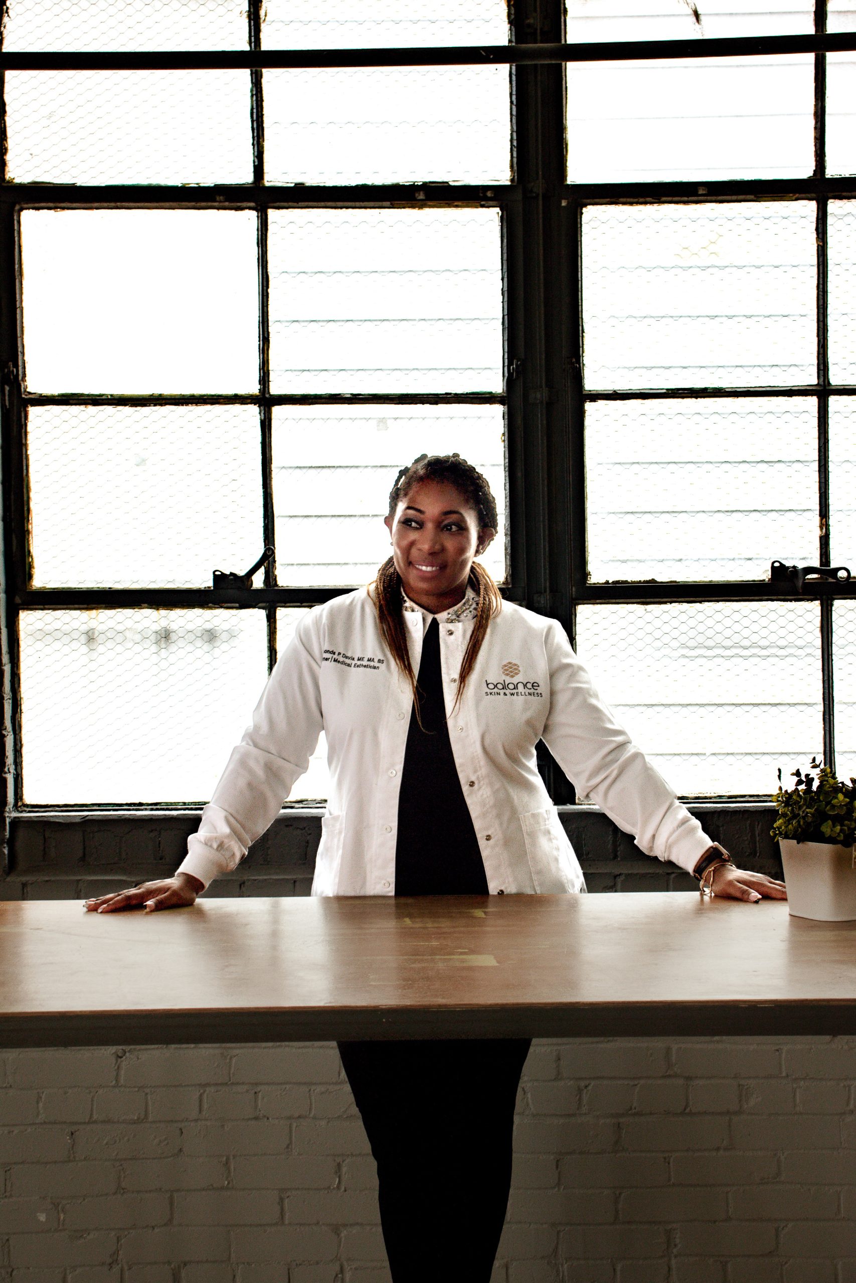 Rashonda Davis, founder of Balance Skin + Wellness, standing confidently in treatment space