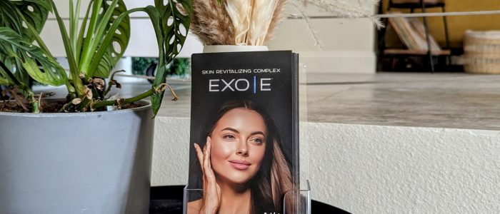 EXO|E skincare brochure displayed with Himalayan salt and greenery at Balance Skin & Wellness, a Black-owned med spa in San Antonio.